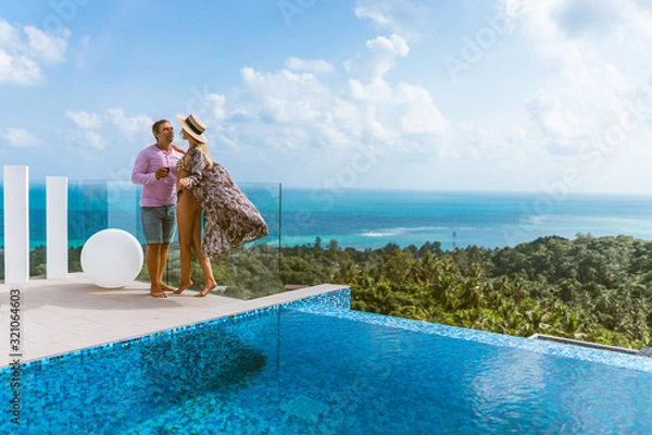 Fototapeta A beautiful couple spends a honeymoon in a luxurious villa with a pool and sea views. Exotic and Romance for Man and Woman in Thailand. Koh Samui