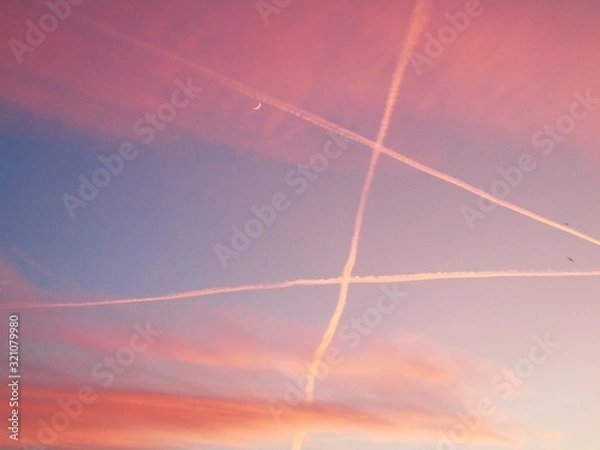 Fototapeta Genova, Italy - 01/25/2020: An amazing caption of the sunset in winter days over the city of Genova with beautiful red sky, some amazing clouds and small moonlight in the background.