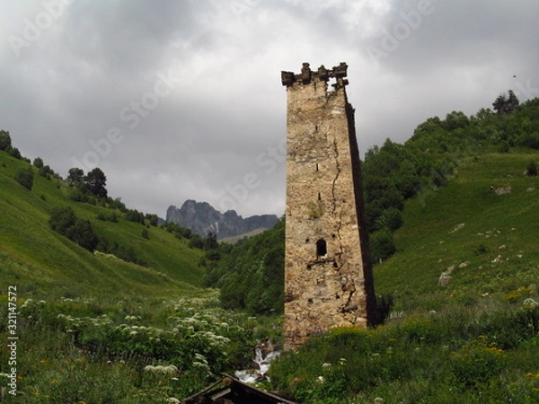 Fototapeta Mountain landscape of Svaneti on bright summer sunny day. Mountain lake, hills covered green grass on snowy rocky mountains background. Caucasus peaks in Georgia. Amazing view on wild georgian nature