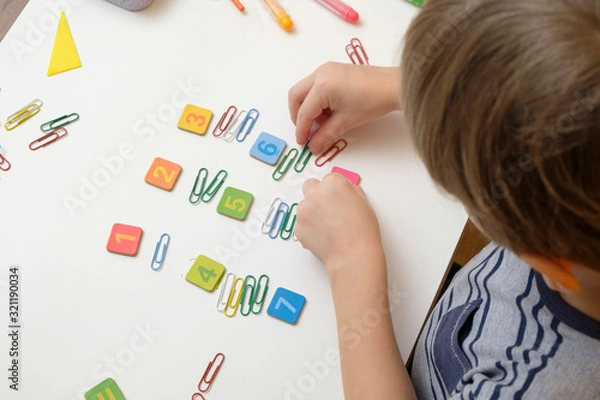 Obraz Back to school. Little boy child preparing for elementary school doing simple math exercises
