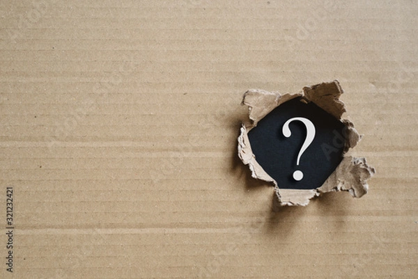 Fototapeta Torned corrugated box revealing question mark. Concept of mystery and uncertainty