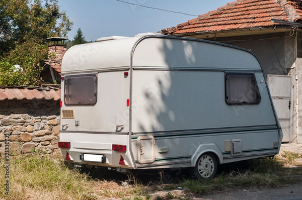 Fototapeta Old vintage caravan side view closeup at country house in sunny day