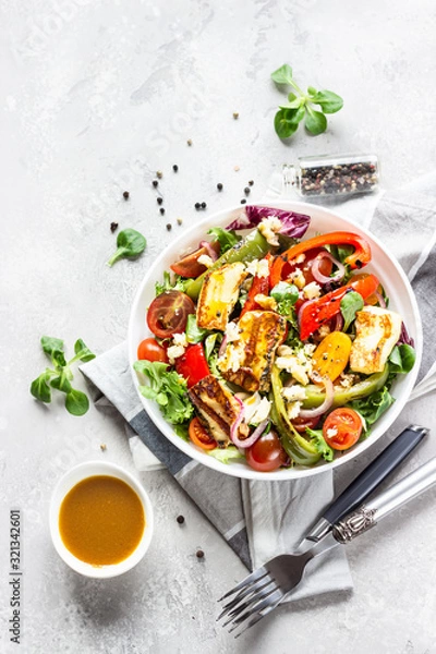 Obraz Vegetable salad cherry tomatoes, baked pepper, salad mix and onion with grilled haloumi (halloumi) cheese. Keto diet, healthy food. Light grey stone background. Top view.