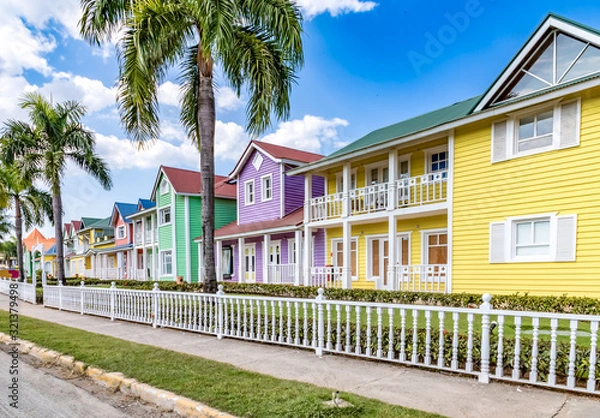 Obraz Typical dominican colorful wood houses, palm trees on an emblematic downtown street, Samana, Dominican Republic
