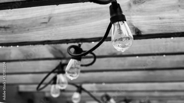 Fototapeta String of hanging lights at pergola for relaxing patio atmosphere in the cool evening.