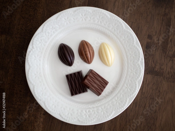 Obraz 白いお皿の上に並べられた様々な種類のチョコレート