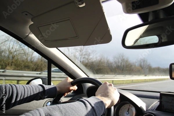 Obraz Man hands and arms driving on the highway