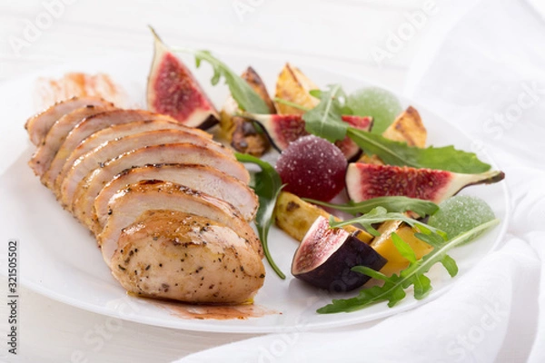 Obraz Baked chicken with fig and arugula salad. Chicken breast, fig, arugula. Dinner. Fried chicken breast with vegetables and figs. Dish with figs. fried chicken with figs and onions. Free space for text. 