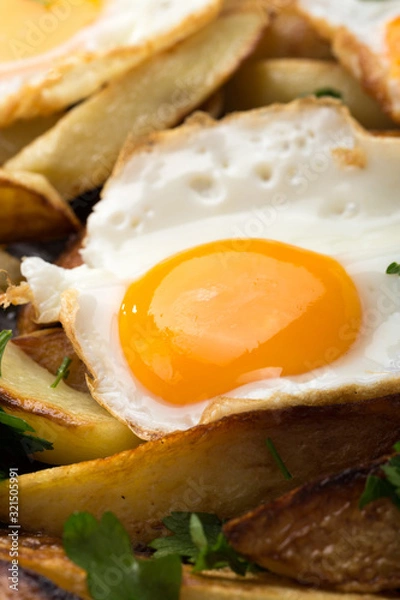 Obraz Breakfast in the pan. Fried potatoes with eggs in a skillet. Food bachelor. Cooked by a man. Hot and fresh. Homemade breakfast on black table. Fried eggs and sweet potato hash in cast iron skillet Fre