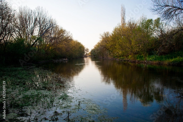 Fototapeta Dawn sky with dark clouds illuminated by the sun.