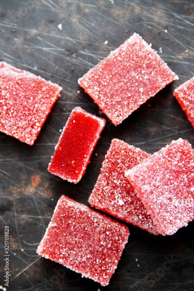 Fototapeta Strawberry pate de fruit (jelly, marmalade, fruit candy) covered with sugar on a dark background, top view