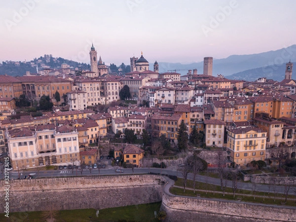 Obraz Bergamo, Italy. Drone aerial view of the old town during sunrise. Landscape at the city center, its historical buildings and the Venetian walls a Unesco world heritage