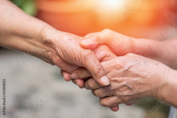 Fototapeta Aging society concept. Hands of old people holding support each other in nursing home