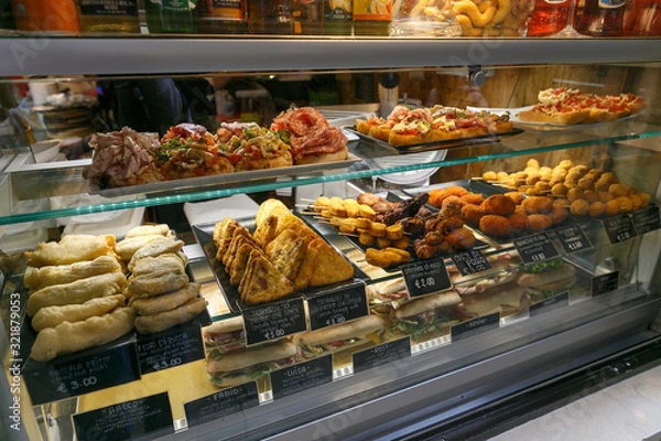 Fototapeta meat snacks, sandwiches on display in an Italian store or bar
