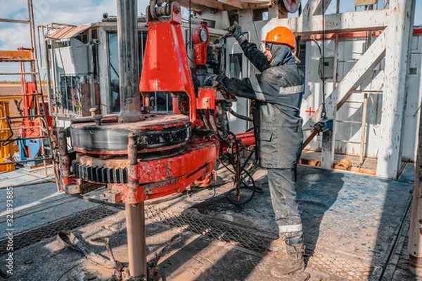 Fototapeta Offshore oil rig worker prepare tool and equipment for perforation oil and gas well at wellhead platform. Making up a drill pipe connection. A view for drill pipe connection from between the stands.