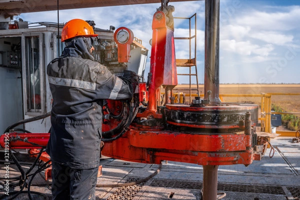 Fototapeta Offshore oil rig worker prepare tool and equipment for perforation oil and gas well at wellhead platform. Making up a drill pipe connection. A view for drill pipe connection from between the stands.