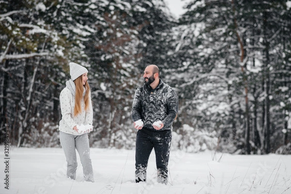 Fototapeta Couple playing with snow in the forest