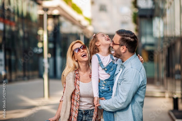 Fototapeta  Happy young family of three smiling while spending time together