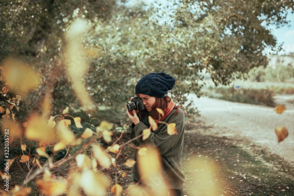 Obraz Young woman taking photos in the forest with an old camera