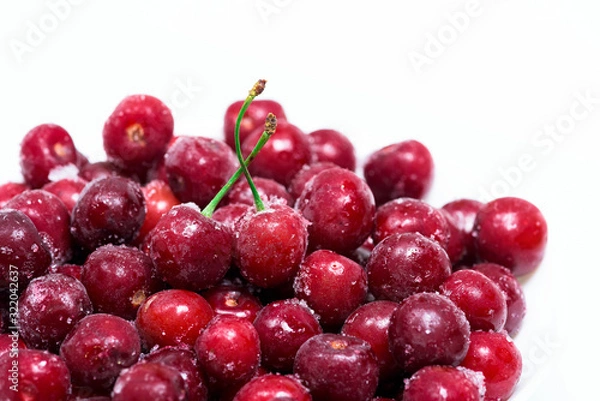 Fototapeta group of frozen cherries on a white background . close-up of berries. ice crystals on the fruit