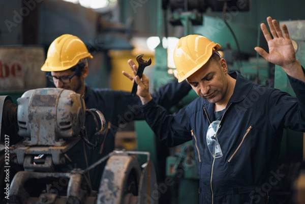 Fototapeta Shot of two industrial workers feeling bad with old system in the factory, the worker feels upset and show give up, Concept industrial workers with bad emotion when working time, working confliction.