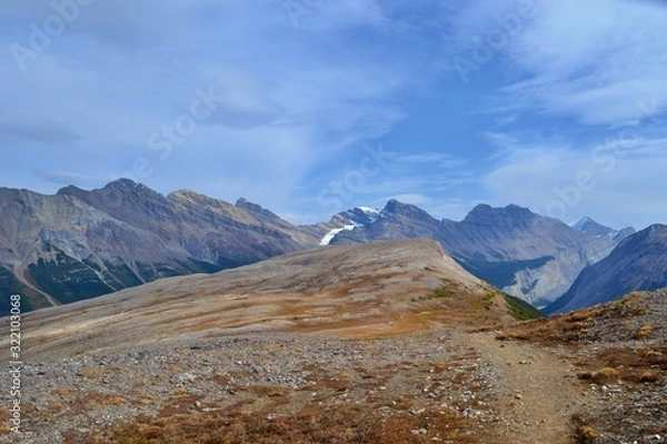 Fototapeta Brown and gray mountains with blue sky and white clouds. Parker Ridge, Banff National park, Canada.