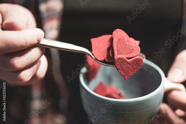 Obraz Woman holding cup full of red heart shape figures. Valentine's day concept. Selective focus.