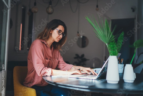 Obraz Młoda kobieta przedsiębiorca pracująca zdalnie z domowego biura przy użyciu nowoczesnego laptopa, kobieta copywriter pracująca online