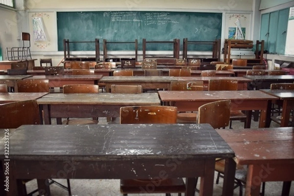 Fototapeta A dilapidated and dirty student desk and chair in classroom