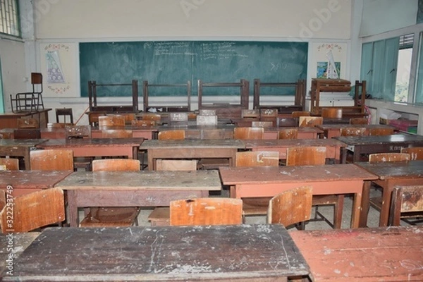 Fototapeta A dilapidated and dirty student desk and chair in classroom