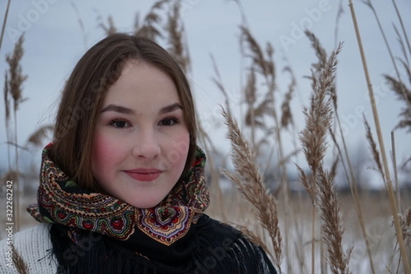 Obraz close-up portrait of a girl in a white sweater and openwork shawl on a background of nature