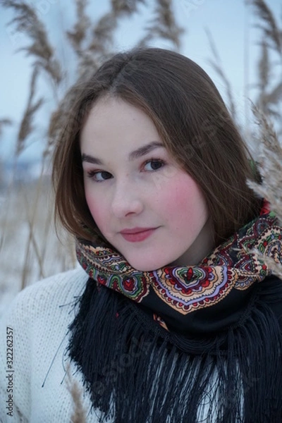 Obraz close-up portrait of a girl in a white sweater and openwork shawl on a background of nature