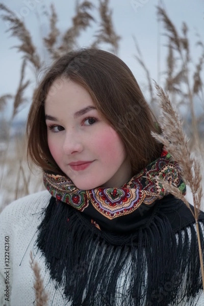 Obraz close-up portrait of a girl in a white sweater and openwork shawl on a background of nature