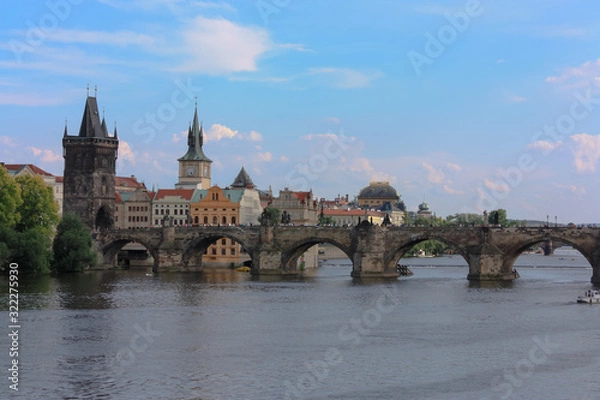 Fototapeta Charles bridge (Karluv most) over Vltava river, Prague, Czech Republic. Summer day. Blue sky with few clouds.