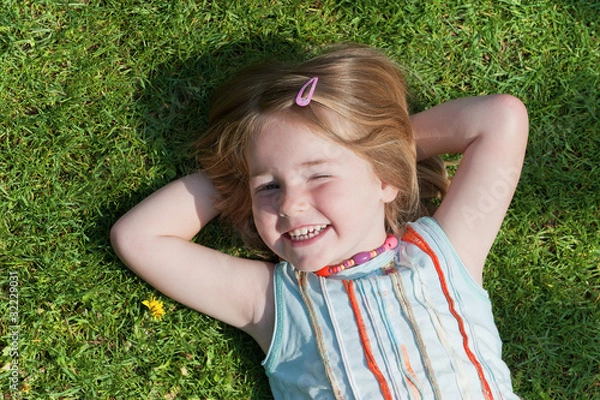 Obraz Mädchen liegt auf dem Rasen