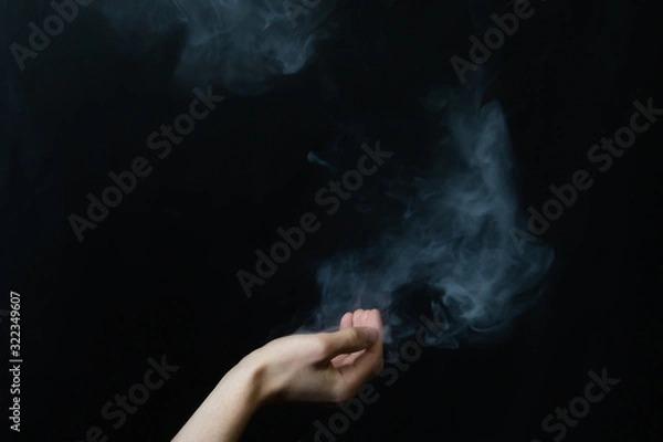 Fototapeta Smoke in hand. abstract fog. hand creates a magic spell