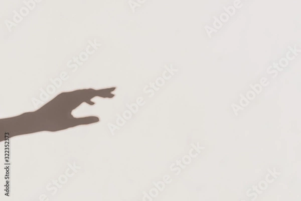 Obraz Grey shadows of one reaching hand on the wall. Abstract blurred effect.