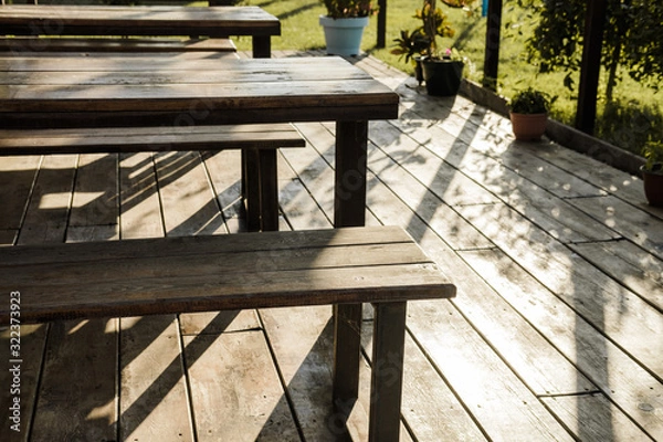 Fototapeta Gazebo in a roadside cafe with plants, wooden tables, benches and flowers around.