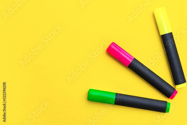 Fototapeta Multicolored markers on a yellow background, top view, copy space