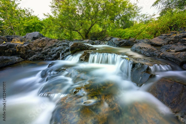 Fototapeta Magical stream in the rainforest with soft flowing water like wool flowing through the cliff creates a peaceful landscape to relax soul and music
