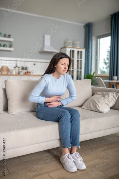 Fototapeta Young woman having a strong shomach ache