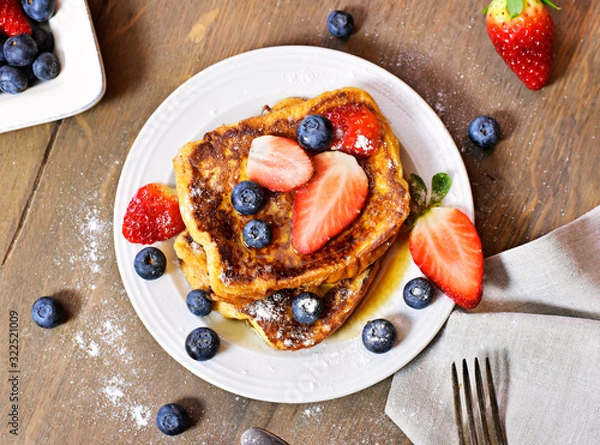 Obraz Delicious french toast with fresh fruits and maple sirup. Tasty breakfast scene or dessert with toast, strawberries, blueberries and powdered sugar.