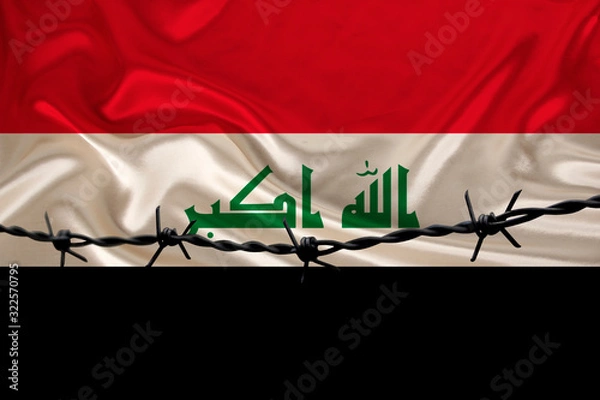 Fototapeta iron barbed wire against the background of the national silk flag of the state of Iraq, the concept of imprisonment for offenders, for the siege area