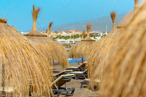 Obraz Beach straw umbrellas at the ocean beach. Seaside resort at summer day. Tourism and travel, vacation.