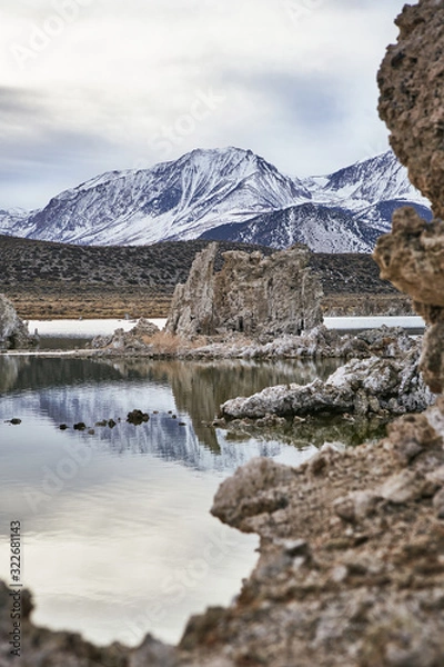 Obraz View of a Saline Soda Lake with Snow Capped Eastern Sierra Navada Mountains on a Cloudy Day in the Afternoon with Sunlight Shinning Through the Cloud 