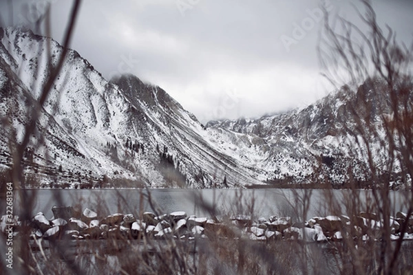Obraz View of Lake on the Mountains in Winter Fog with Dramatic Snow Capped Mountains in the Background 