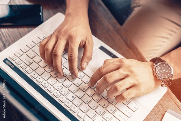 Obraz Working with laptop, hands typing on laptop keyboard at the office.