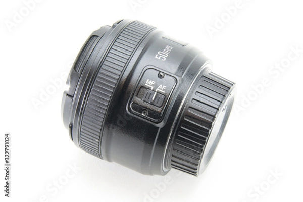 Fototapeta A black lens with 50mm covers with a 1.8 aperture lies on its side on a white isolated background