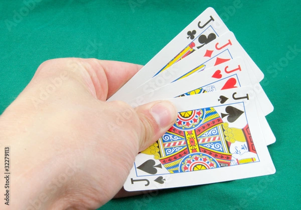 Fototapeta four jacks in hand on card table