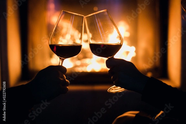 Obraz Young couple have romantic dinner with wine over fireplace background